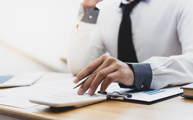 Business men use calculators to calculate the company's tax and revenue in the office, Financial and accounting banking concepts.