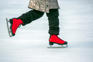 Naklejka premium feet in red skates on an ice rink. Hobbies and sports. Vacations and winter activities.