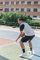Obraz premium Athlete plays basketball very concentrated to keep track of his ball
