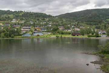 Fototapeta na wymiar village on green lake shore, near Al, Norway