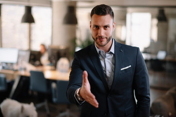 Fototapeta premium Businessman gives a hand for handshaking 