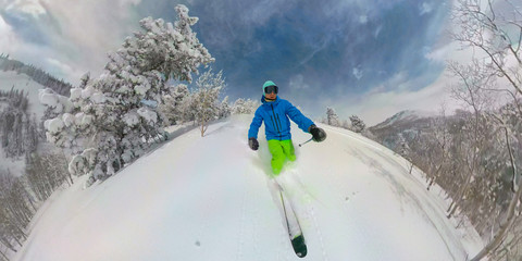 Fototapeta SELFIE Athletic male tourist shreds the fresh powder snow while skiing off piste obraz