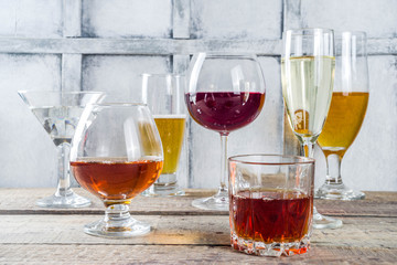 Selection of different alcoholic drinks - beer, red white wine, martini, champagne, cognac, whiskey in various glasses