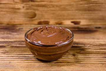 Glass bowl with chocolate spread on a wooden table