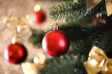 Obraz na płótnie Canvas Christmas fir tree with ornaments on blurred lights background
