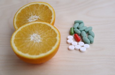 Fototapeta premium Choice between healthy lifestyle and lecture, choice between vitamin in orange or pills