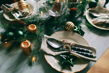 Table served for winter dinner in living room. Close up view, table setting. Christmas and winter decorations.