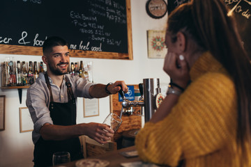 barman pouring beer from tap