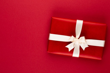 Christmas, holiday present box on red background.
