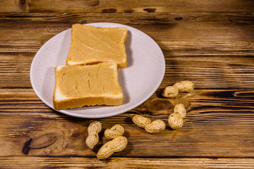 Sandwiches with peanut butter in plate on a wooden table