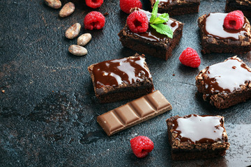chocolate brownie cake dessert with raspberries and spices on a wooden background.