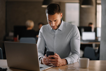 Obraz premium Portrait of handsome businessman using phone