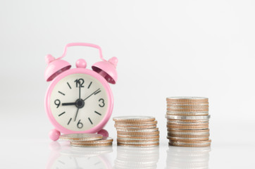 Pink clock and coins on white background. Business and finance concept for future.