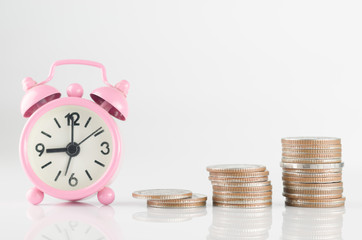 Pink clock and coins on white background. Business and finance concept for future.