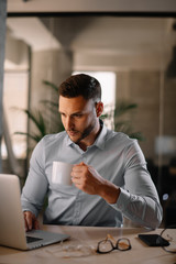 Obraz premium Portrait of handsome businessman working in office and drinking coffee.