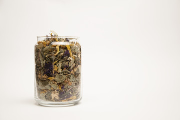 Tasty herbal tea in a glass jar. On white background