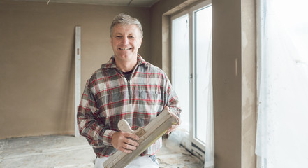 Friendly plasterer in the interior of newly constructed house