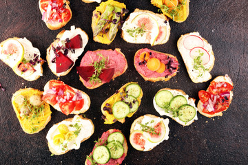 Assorted bruschetta with various toppings. Appetizing bruschetta or brie crostini. Variety of small sandwiches. Mix bruschetta on table