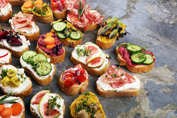 Assorted bruschetta with various toppings. Appetizing bruschetta or brie crostini. Variety of small sandwiches. Mix bruschetta on table