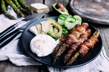 Baked asparagus in bacon with egg, avocado and cheese
