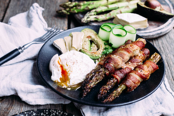 Baked asparagus in bacon with egg, avocado and cheese