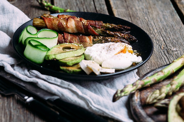 Baked asparagus in bacon with egg, avocado and cheese
