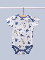 Baby bodysuit hanging on a clothesline isolated on blue background/ Close-up/ Top-view/ Baby clothes 