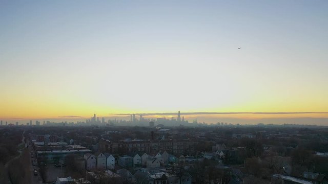 Plane Flies Over Sleepy Neighborhoods Toward Chicago Skyline at Dawn