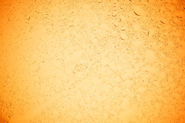 Rain droplets on yellow glass background, Water drops on yellow glass.