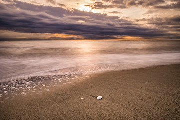 sunset reflected on the waves of the sea in winter on December in Lido di Ostia Rome Italy