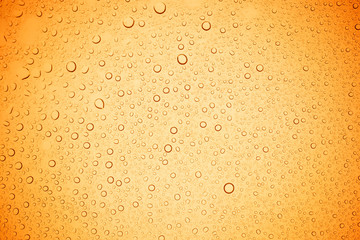 Rain droplets on yellow glass background, Water drops on yellow glass.
