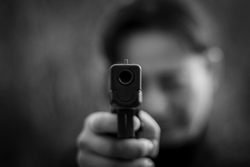 Woman pointing a gun at the target. - selective focus on front gun.