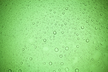 Rain droplets on green glass background, Water drops on green glass.