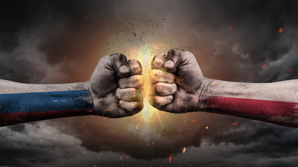Russia vs Poland. Fists with flags. Battle of two countries on sky.	