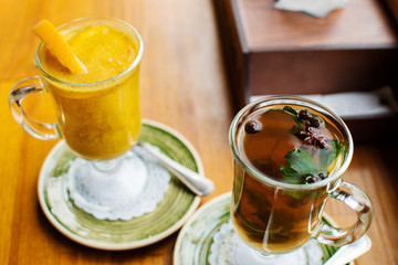 two warming traditional drinks grog and mulled wine with orange and cinnamon on a dark background close up