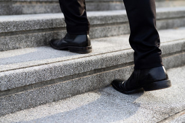 modern businessman working  close-up legs walking up the stairs in modern city. in rush hour to work in office a hurry. During the first morning of work. stairway. soft focus.