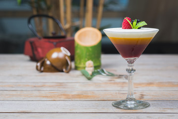 Tiramisu traditional dessert in a glass goblet on a wooden table.