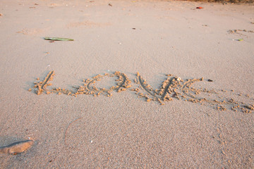 The empty beach floor has the word love.