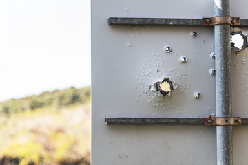 Road sign with bullet holes.