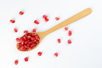 Red Pomegranate seed wooden spoon white background