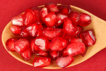 Red Pomegranate seed wooden spoon red paper background
