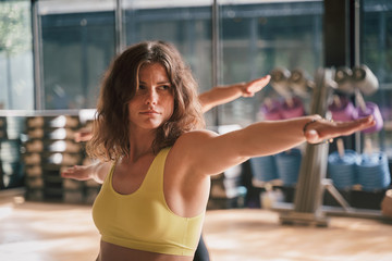  Young of caucasian in sportswear practicing yoga pose warrior and  Virabhadrasana  in the gym, Concept of relaxation and meditation