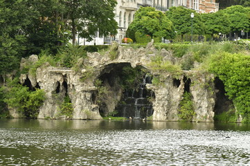 La fausse grotte en rocaille couverte de végétation au lac du square Marie-Louise à Bruxelles