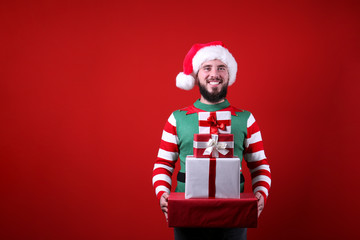 Studio portrait of handsome bearded man wearing traditional elf costume, green vest & striped...