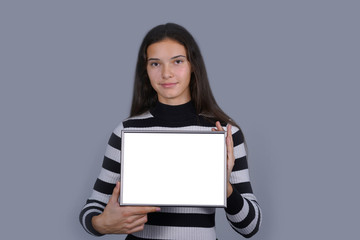 Naklejka premium brunette teen girl holds mock-up horizontal frame poster