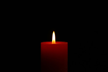 Glowing candle on black background, space for text