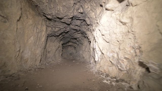Speleology artificial cave dark tunnel excavation underground. Old adit for the extraction of metal and rocks