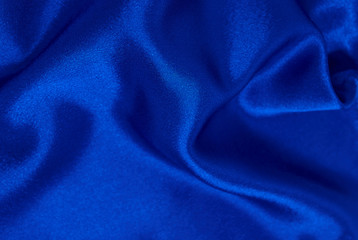 Background of blue satin fabric in folds