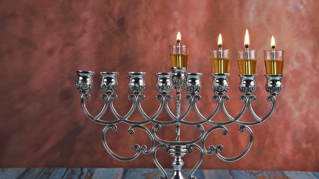 Lights candles on the third day of the Jewish holiday Hanukkah. candles are burning on light of menorah
