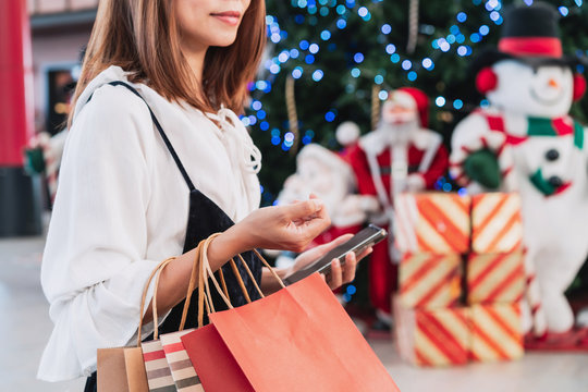 Young woman with shopping bags at shopping mall, Christmas sale concept